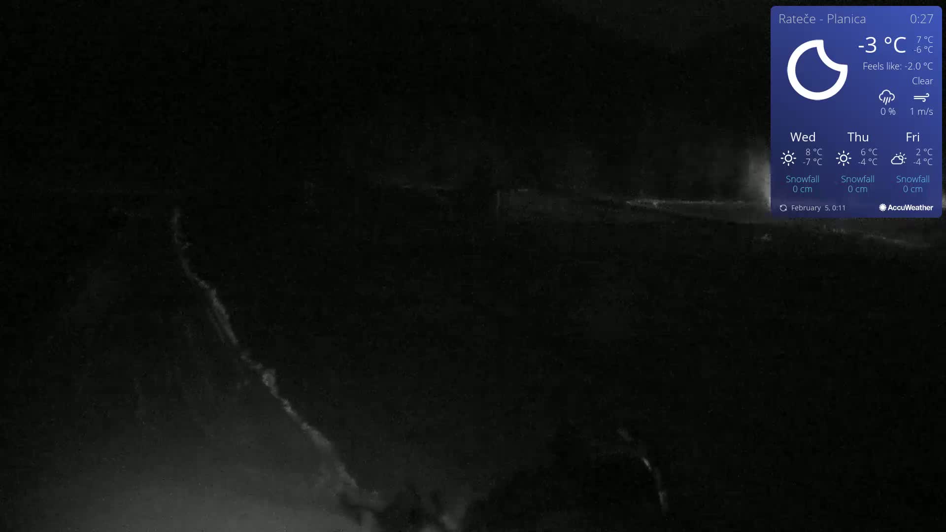 A dark, nighttime scene under a clear sky shows a dimly lit, snowy landscape.