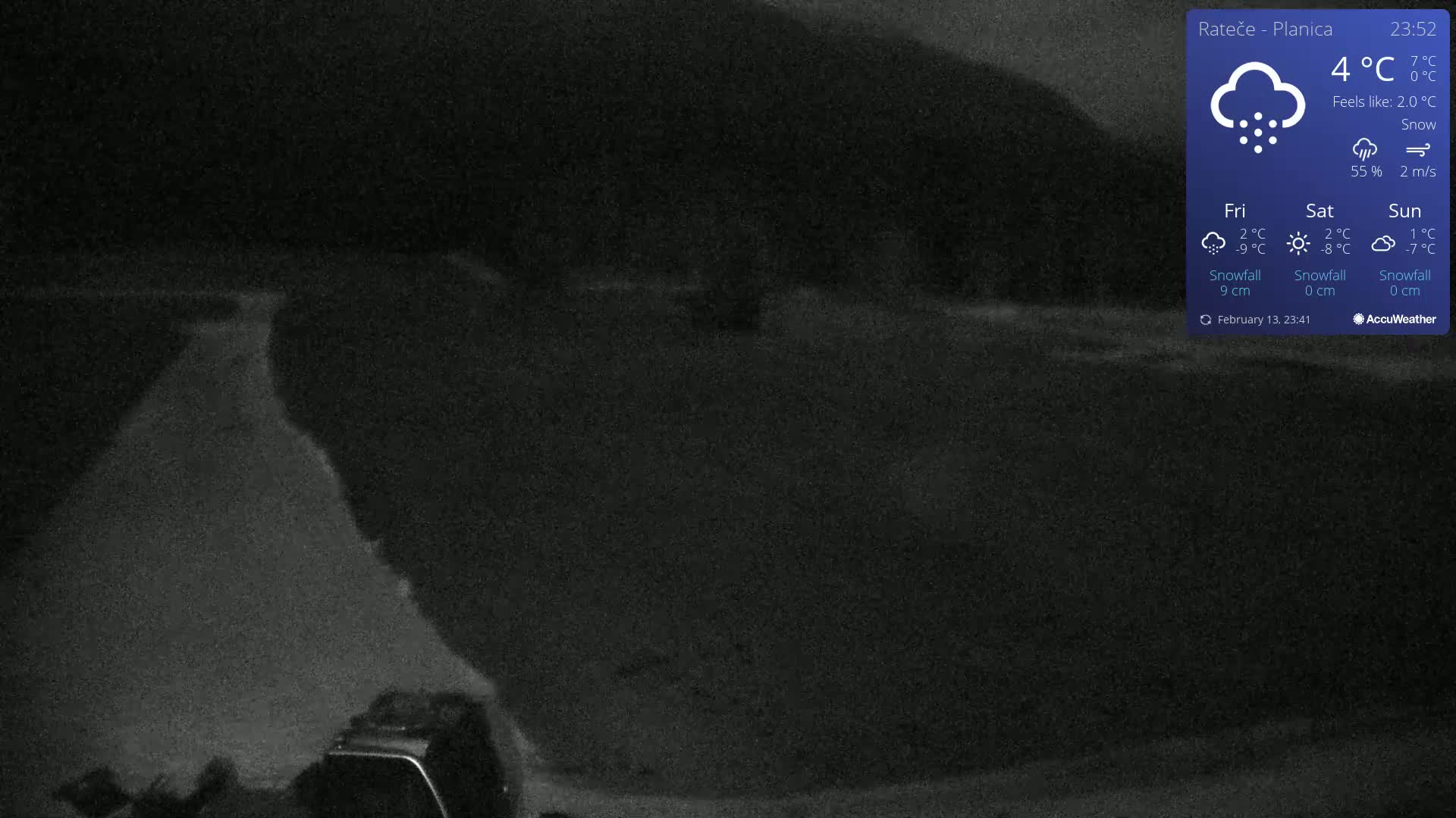 A dark, snowy landscape is visible at night, showing a road leading towards a dark hill.