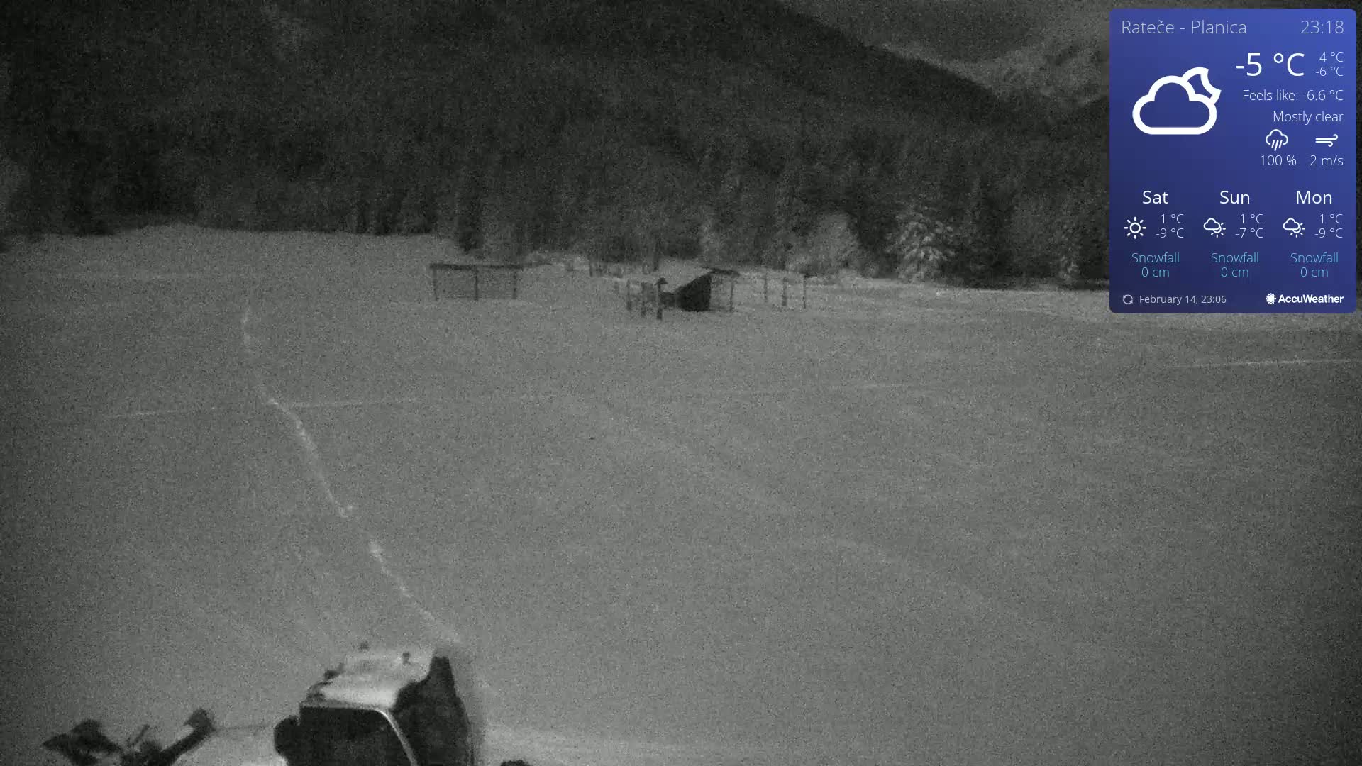 A snow-covered field at night with a vehicle in the lower left corner, under mostly clear skies.