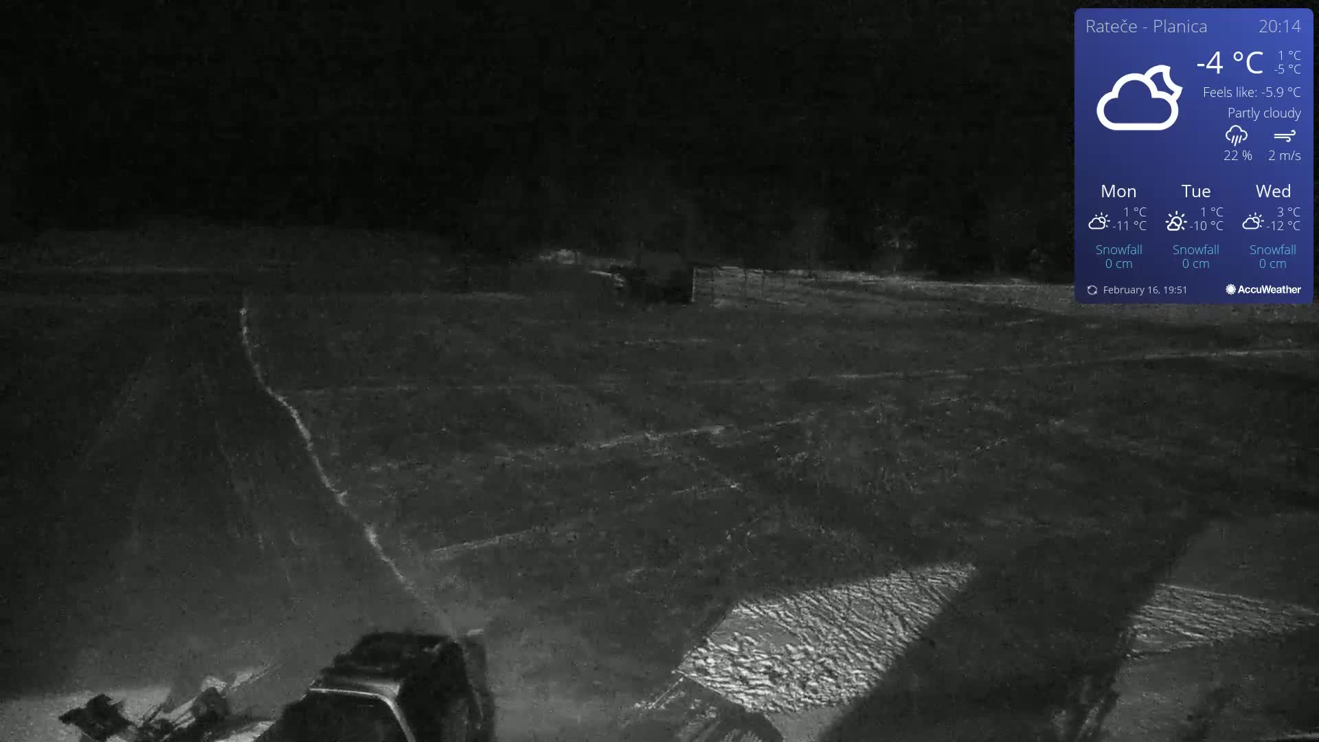 A dark, partly cloudy night scene shows a snow-covered field with a piece of machinery in the lower right corner.