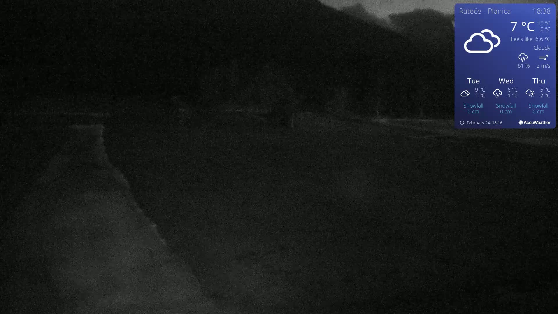 A dark, cloudy night scene shows a road curving through a dimly lit landscape.