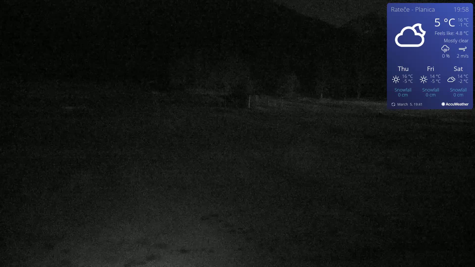 A mostly clear night scene shows a dark field and distant dark trees under a 5°C temperature.