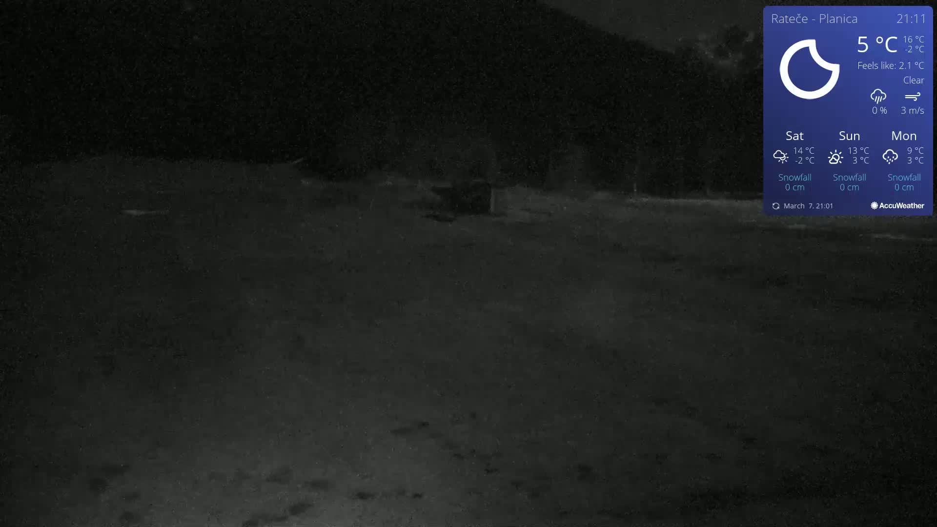A dark, nighttime outdoor scene shows a mostly empty, flat, dark gray area with a small, indistinct object in the middle distance under a clear sky.