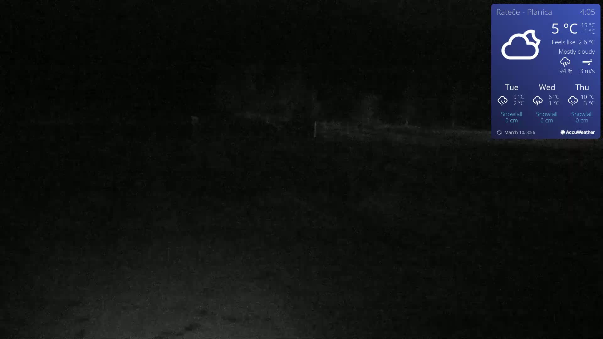 A dark, nighttime outdoor scene under mostly cloudy skies shows a dimly lit landscape.