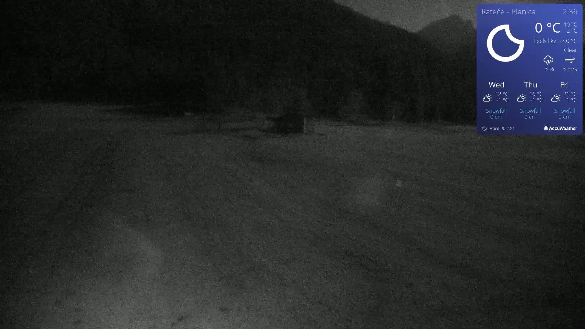 A dark, clear night scene shows a flat, dark expanse of ground under a dark sky and silhouetted mountains in the background.