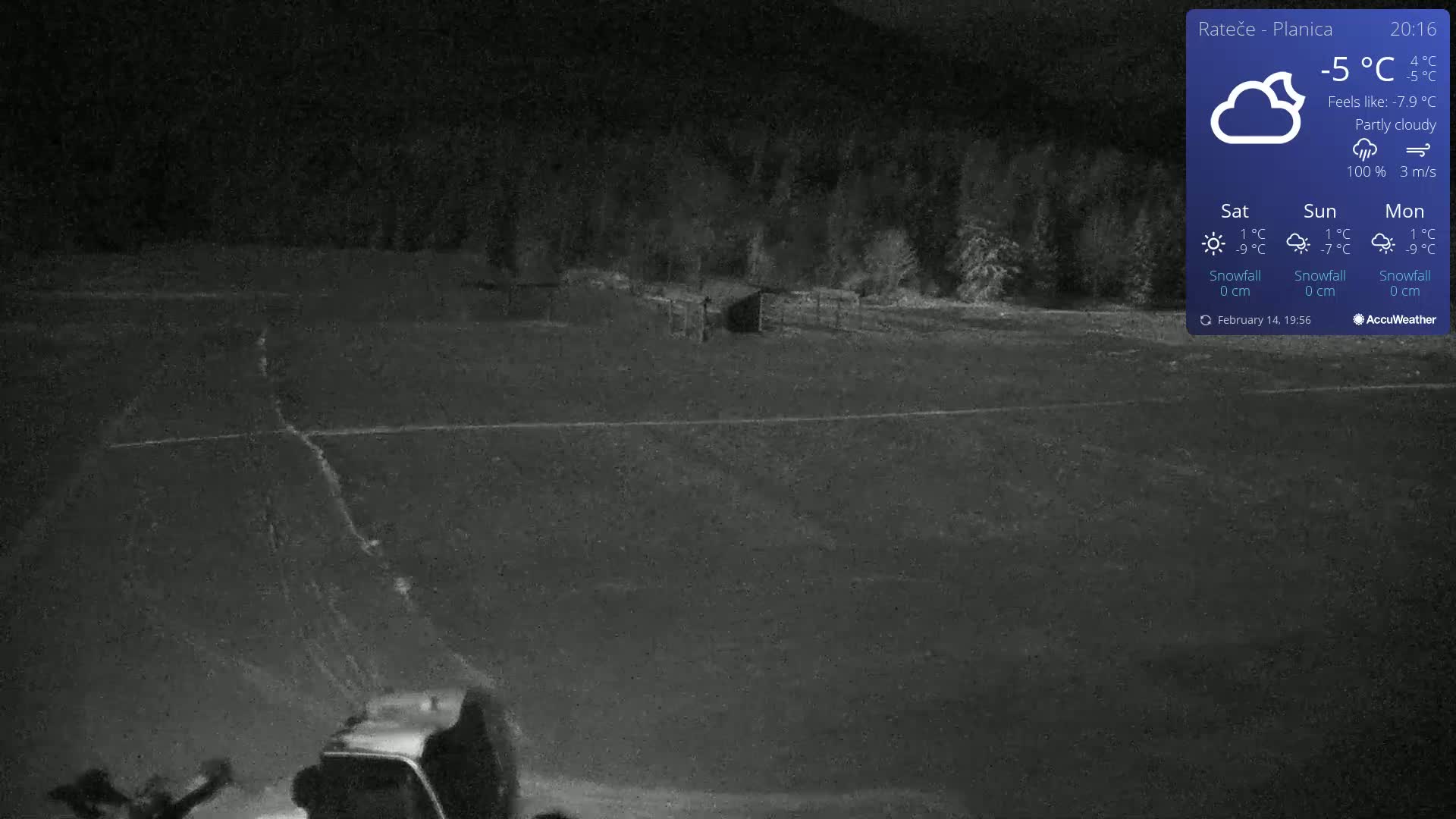 A nighttime, partly cloudy scene shows a snow-covered field with a vehicle and a small structure in the background under a -5°C temperature.