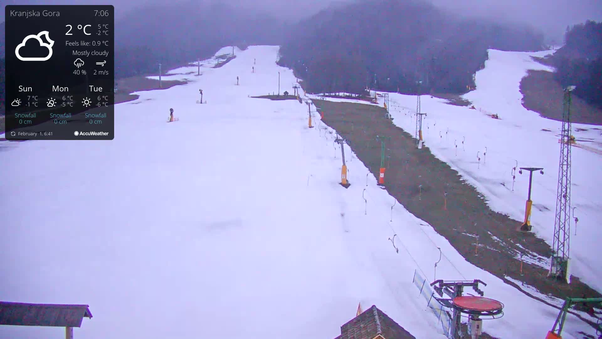 A mostly cloudy, snowy ski slope with several ski lifts is visible under a gray sky.