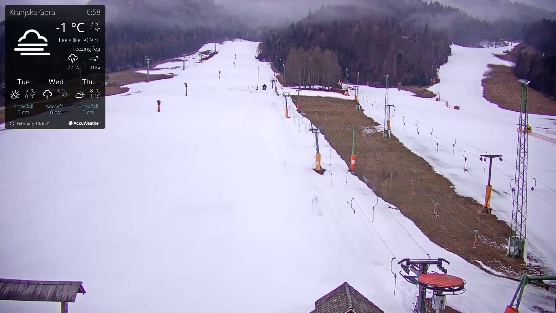 A snow-covered ski slope with chairlifts is visible under freezing fog.