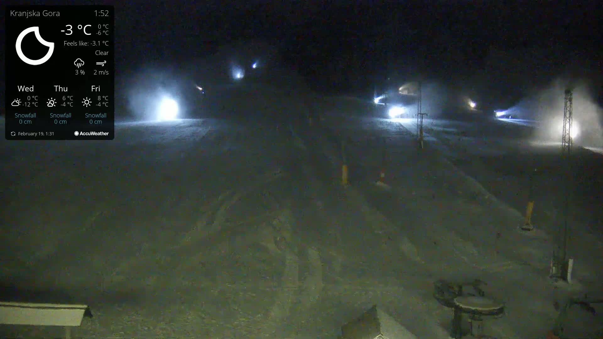 A nighttime, snow-making operation illuminates a ski slope under a clear sky.