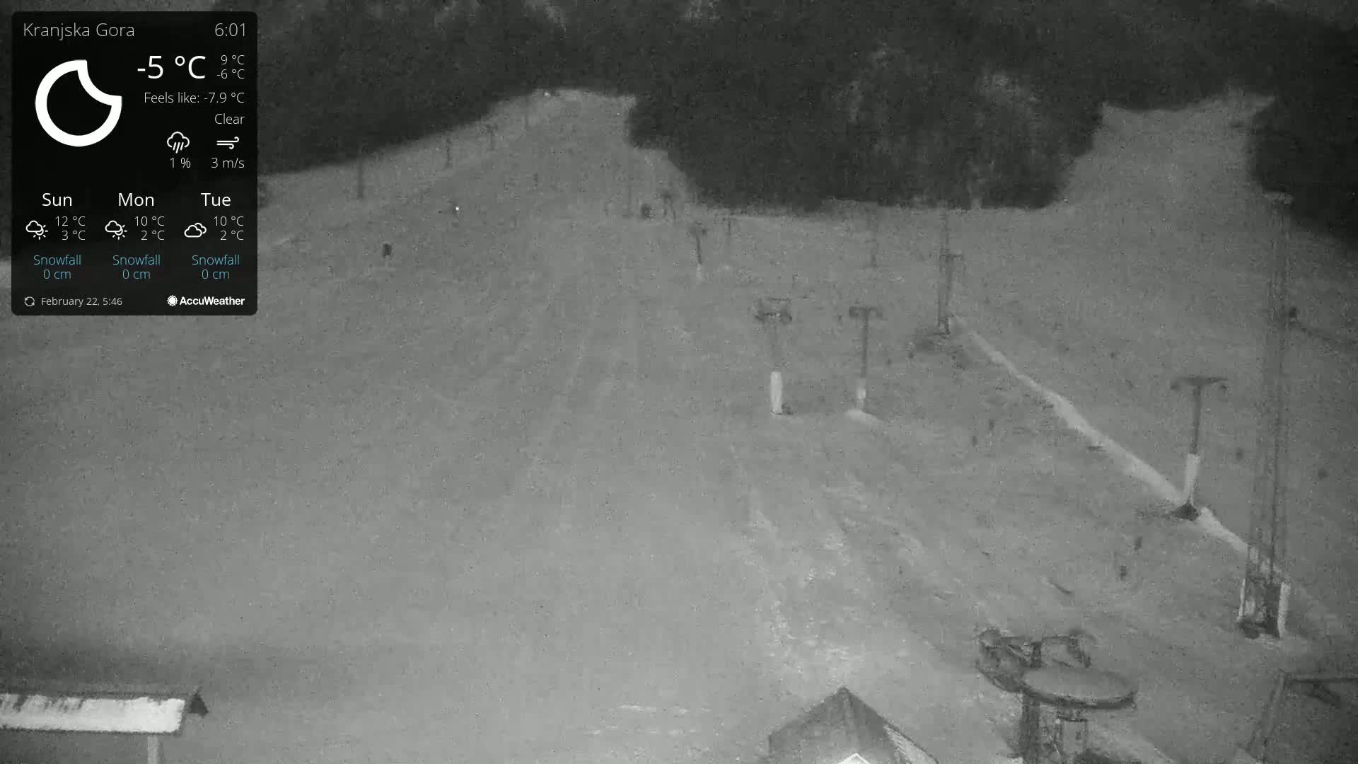 A nighttime, clear view of a snow-covered ski slope with several ski lifts visible under a cold, clear sky.