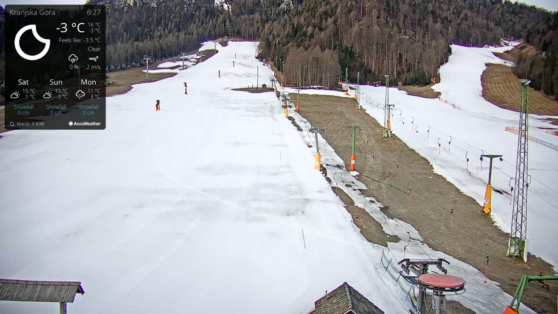 A snow-covered ski slope with ski lifts and a clear sky is visible on a cold day.