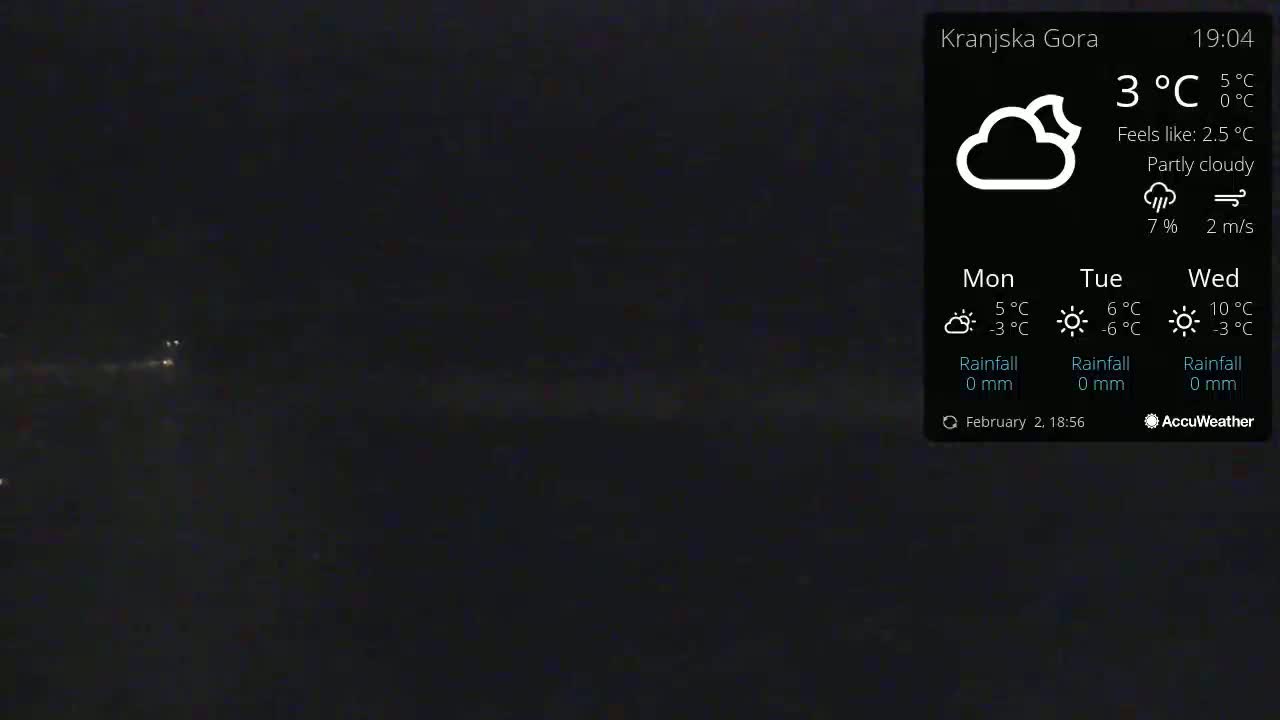 A dark, partly cloudy night scene shows a few distant lights.
