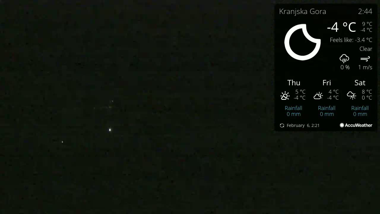 A dark night sky with a few faint lights visible under clear conditions and a temperature of -4°C.