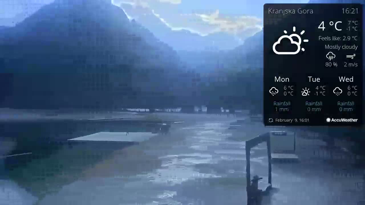 A mostly cloudy, rainy scene shows a body of water with docks and a mountain in the background.