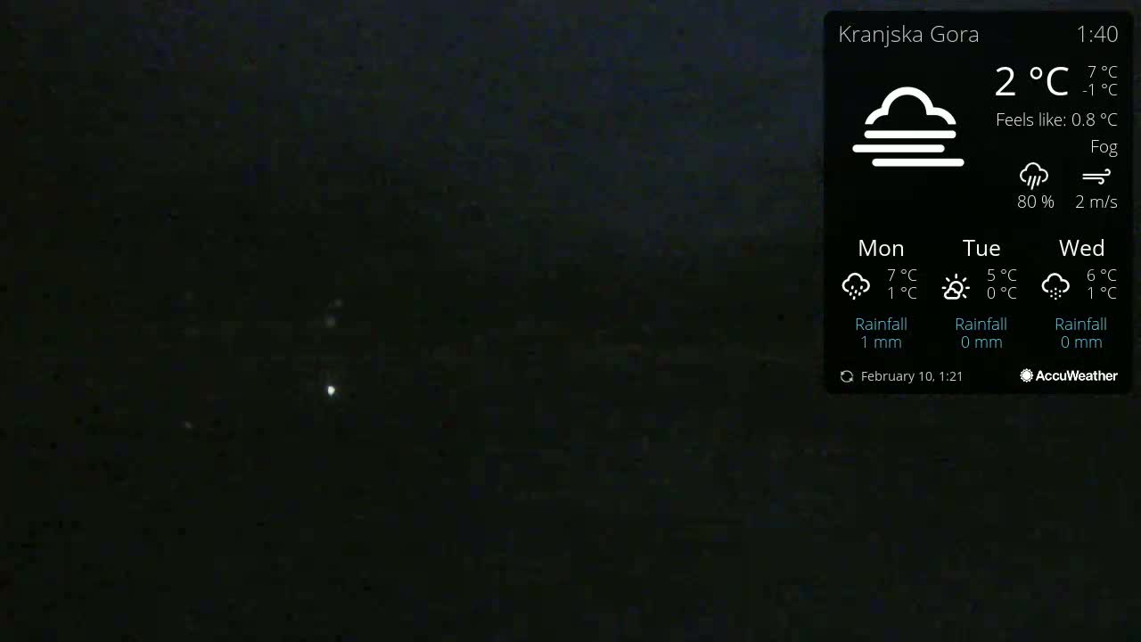 A nighttime, foggy outdoor scene shows a dark sky with a few faint lights visible in the distance.