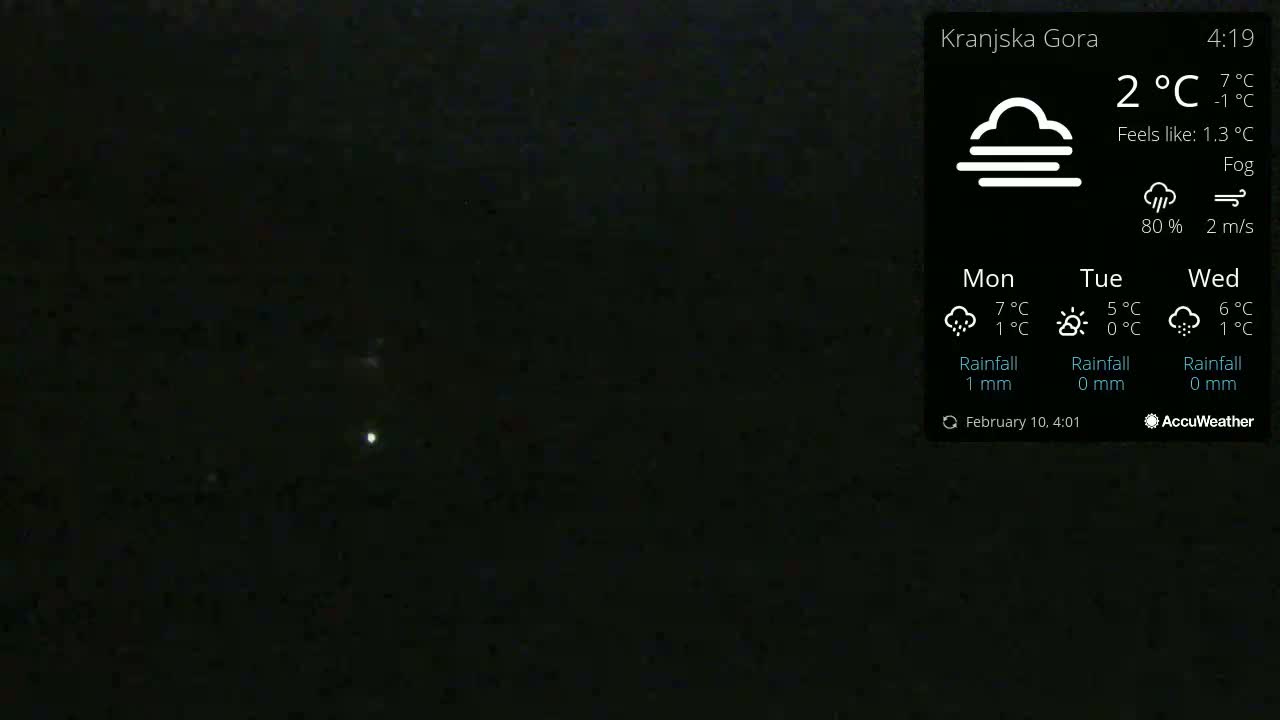 A dark, foggy nighttime scene with two faint lights visible in the distance.