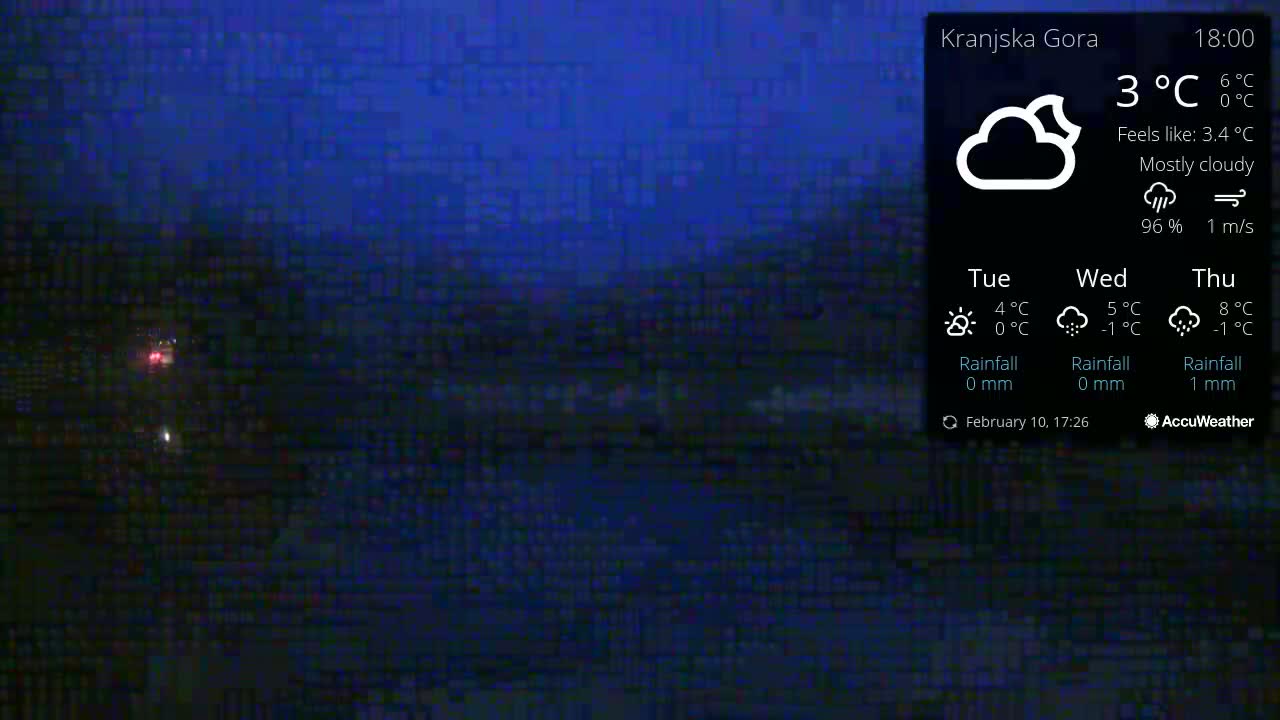 A mostly cloudy night scene with a temperature of 3°C and a light wind is shown, displaying faint, distant lights.