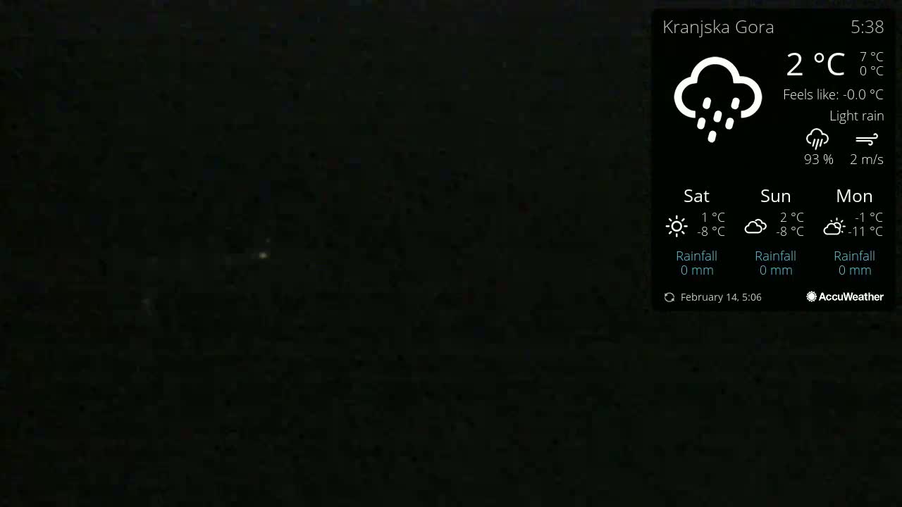 A dark, nighttime scene with light rain.