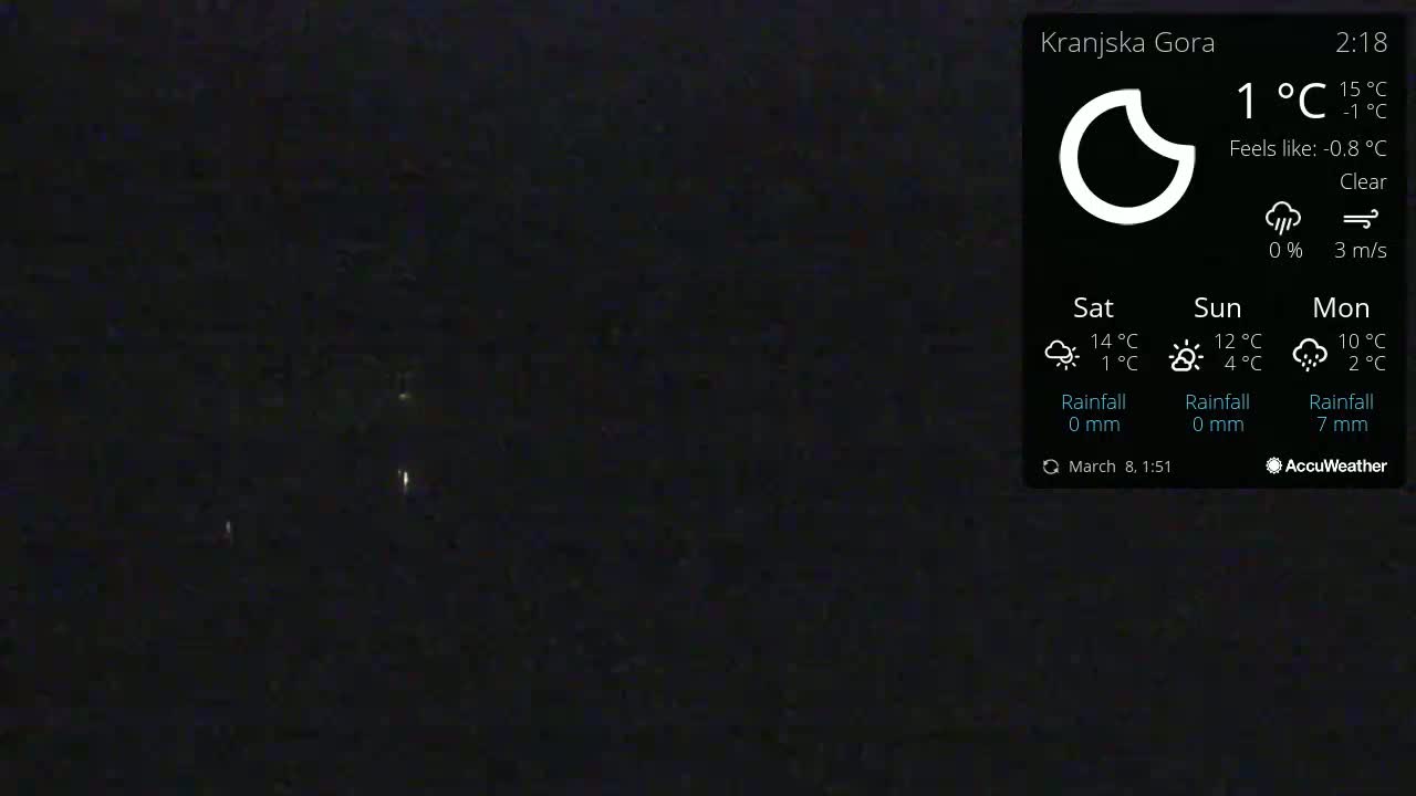 A nighttime outdoor scene shows a dark, clear sky with a few distant lights visible.