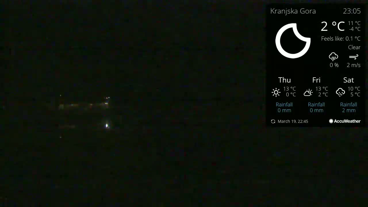 A nighttime, clear view shows dimly lit buildings and some distant lights.