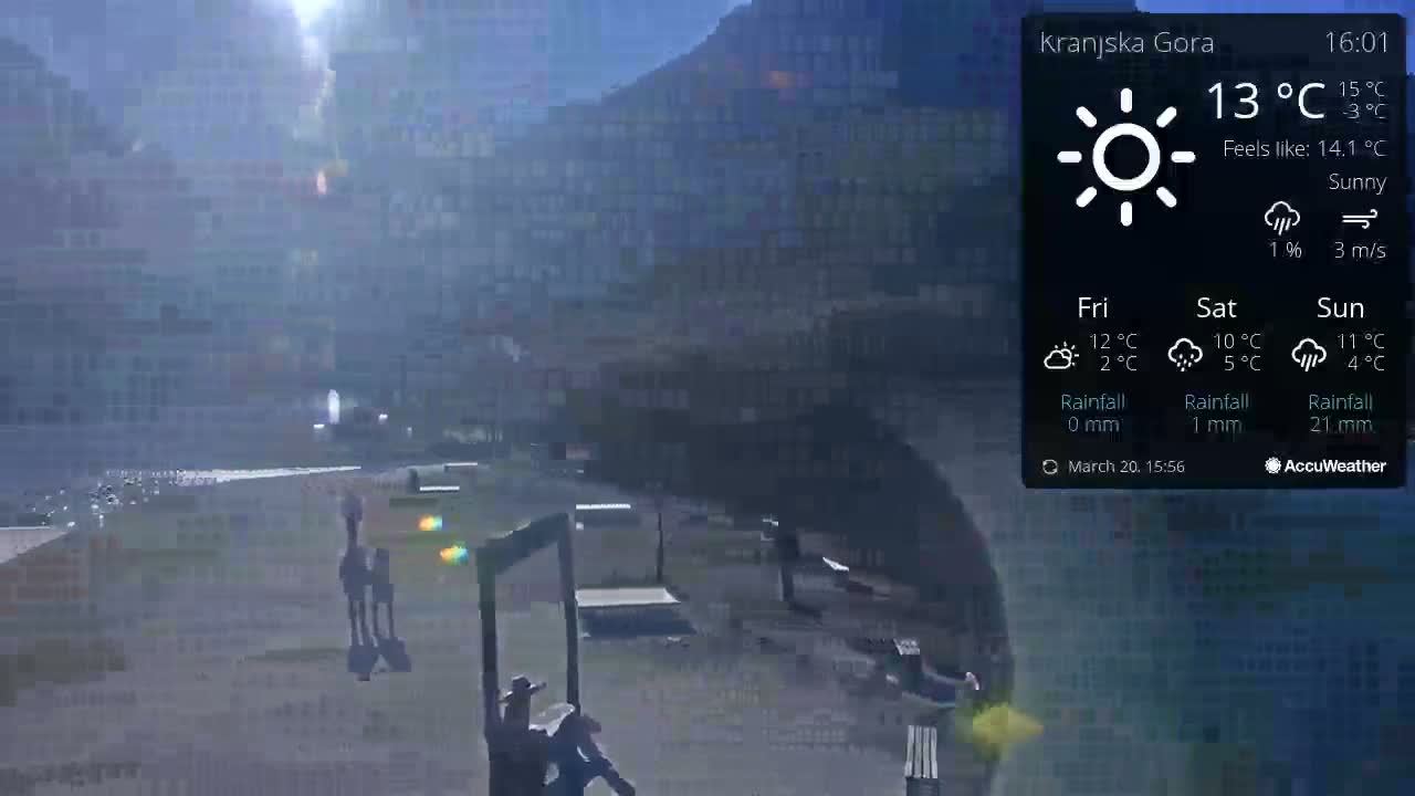 A sunny outdoor scene shows a plaza with several benches and two figures in the distance, set against a hazy backdrop of mountains.
