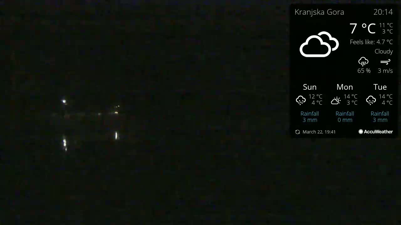 A nighttime, cloudy outdoor scene shows faint lights in the distance under a 7°C cloudy sky.