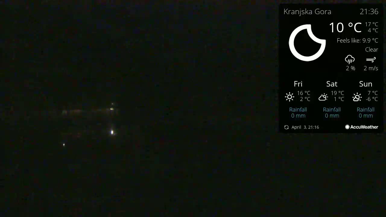 A nighttime outdoor scene shows a dark sky with a few distant lights under clear conditions.