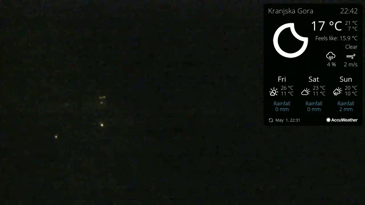 A nighttime image shows a few distant lights in a clear sky.