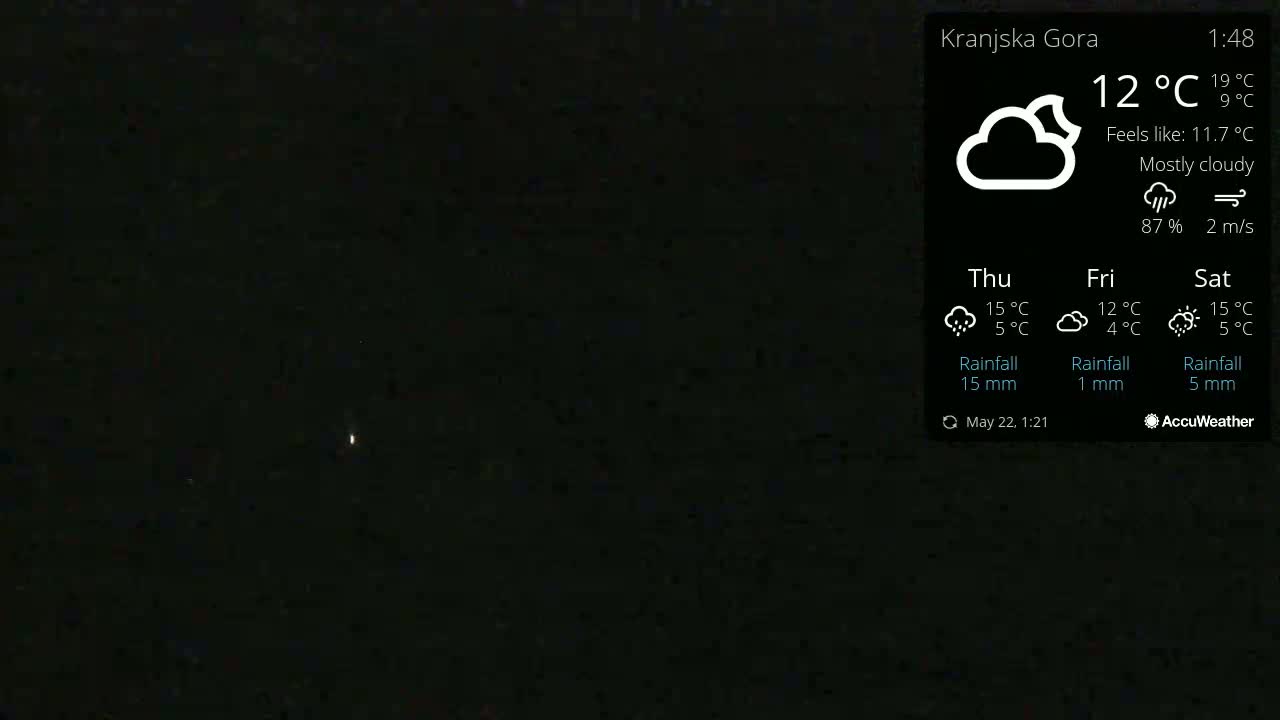 A dark, mostly cloudy night sky shows two faint points of light.