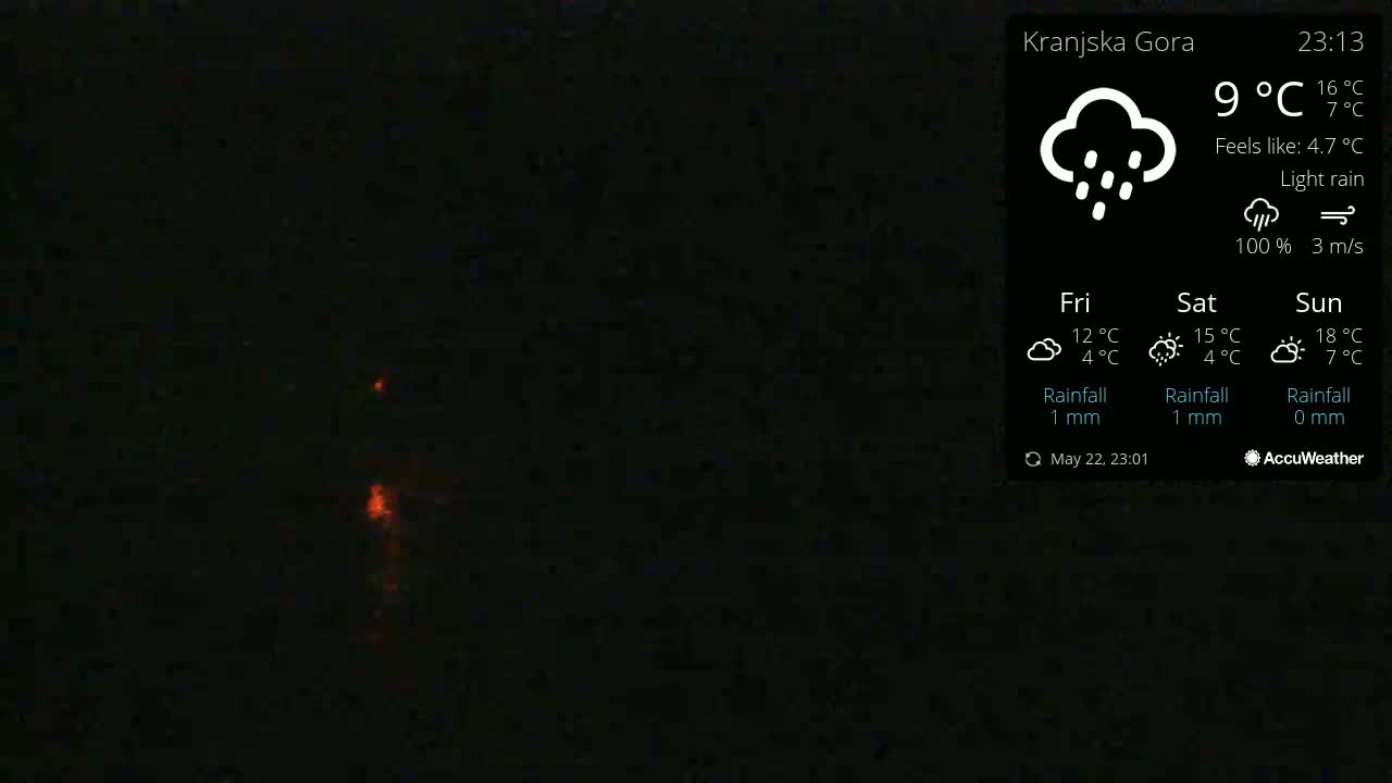 A dark, nighttime outdoor scene shows light rain with a faint orange glow near the bottom.