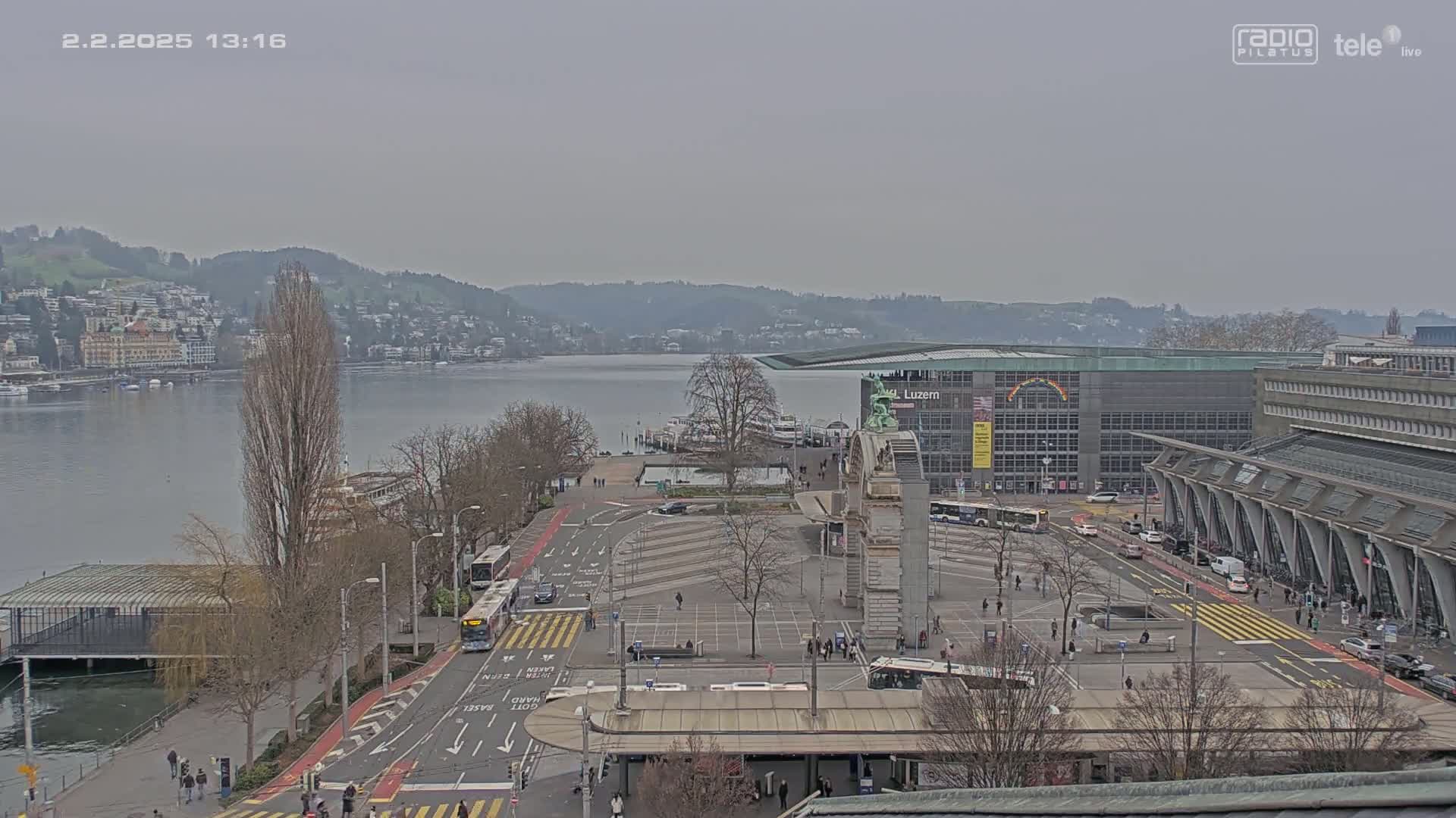 A city square with a body of water and buildings in the background, on an overcast day.