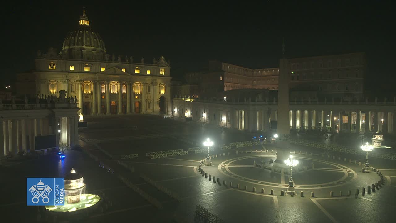 St. Peter's Basilica and St. Peter's Square are illuminated at night, with a fountain in the center of the square and minimal pedestrian traffic.