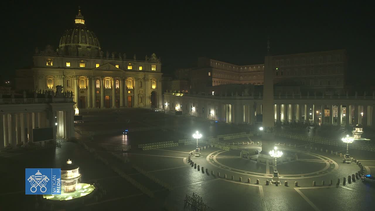 St. Peter's Basilica and Square at night, illuminated, with a mostly empty plaza and wet pavement.