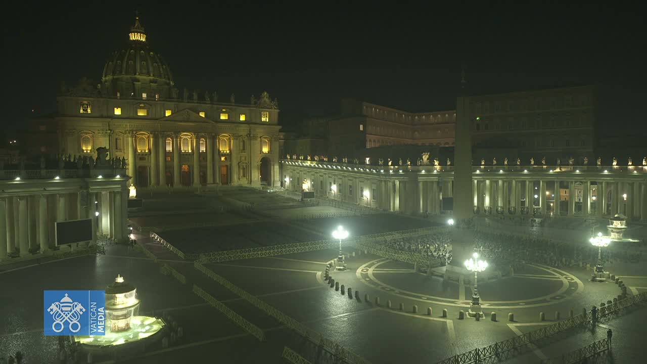 St. Peter's Basilica and Square at night, illuminated, with a sparsely populated plaza.