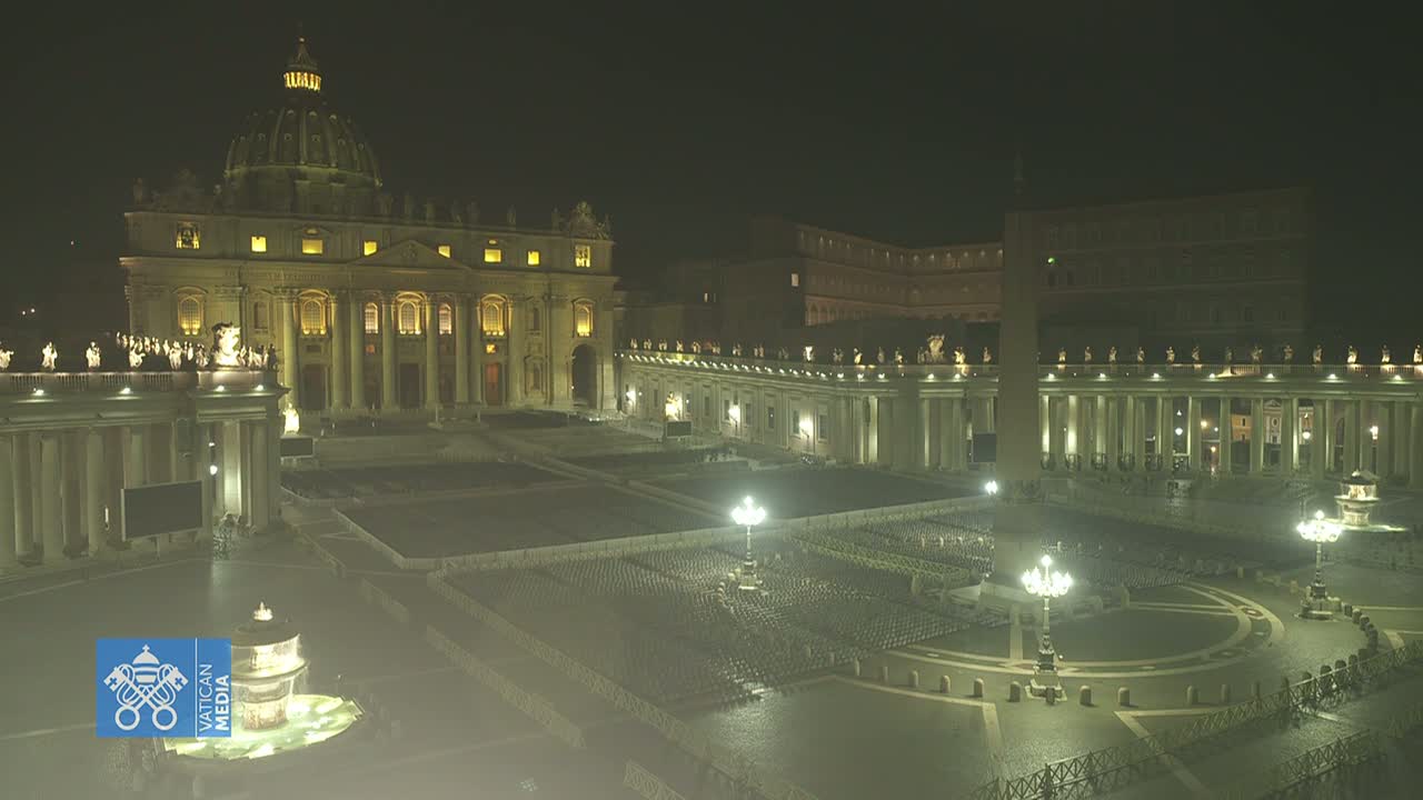 St. Peter's Basilica and Square at night, illuminated, with empty chairs set up in the square.