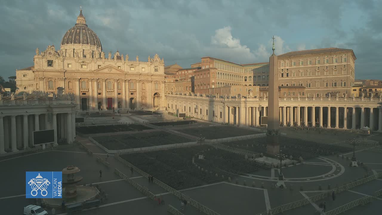 St. Peter's Basilica and St. Peter's Square in Vatican City are shown under a partly cloudy sky during the late afternoon.