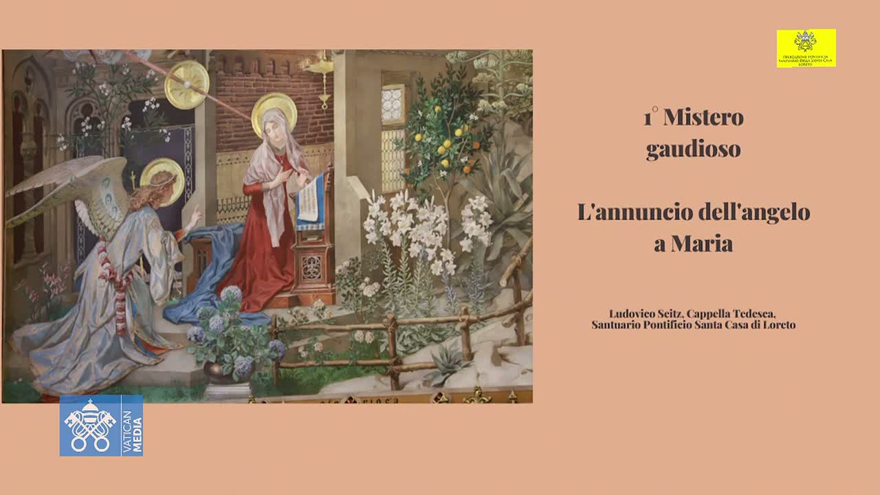 A painting depicts the Annunciation, showing an angel kneeling before Mary, who sits reading a book in a garden setting with flowering plants and a citrus tree.