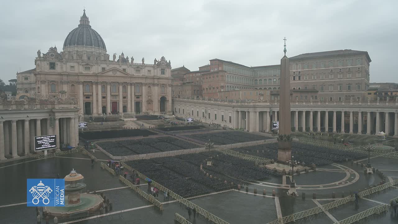 St. Peter's Basilica and St. Peter's Square in Vatican City are shown on an overcast, rainy day, with many empty chairs set up in the square.