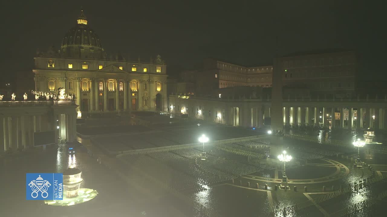 St. Peter's Basilica and St. Peter's Square are illuminated at night in the rain.