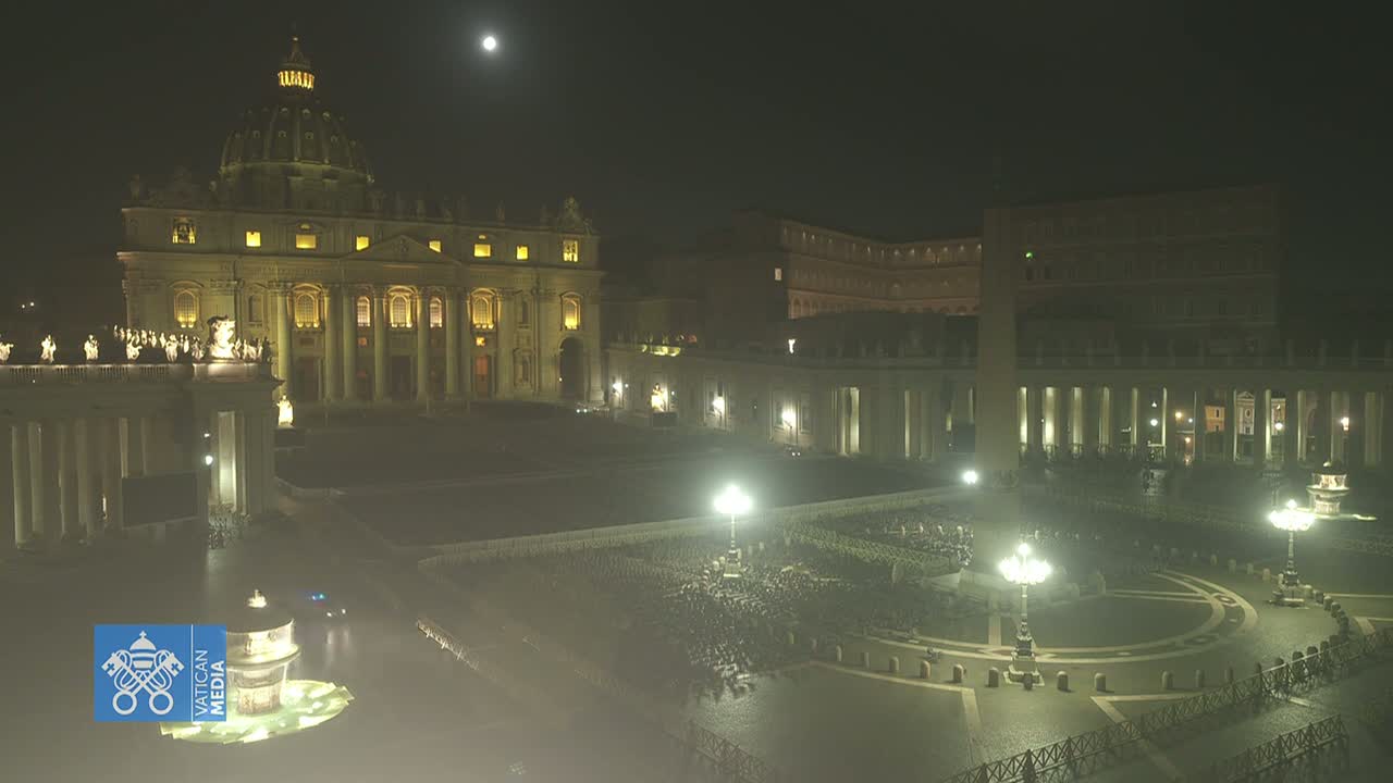 St. Peter's Basilica and St. Peter's Square are illuminated at night under a clear sky with a visible moon.
