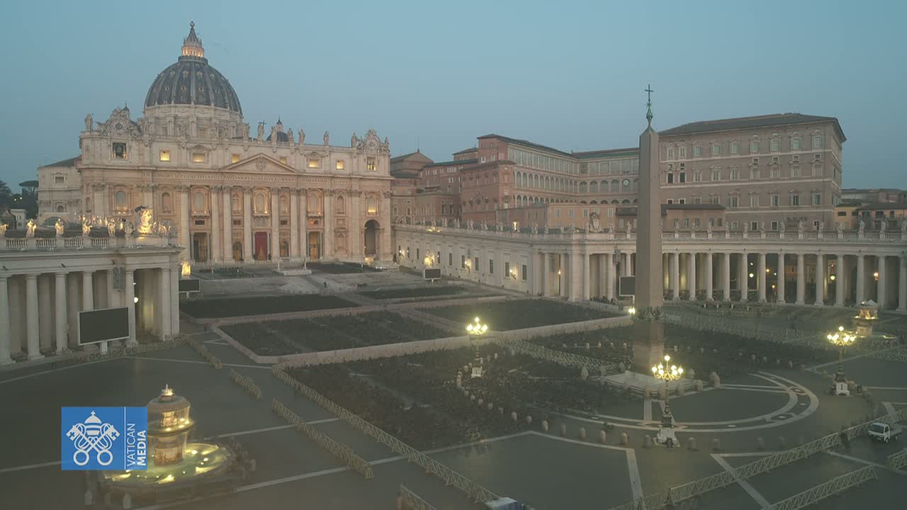 St. Peter's Basilica and St. Peter's Square are shown at dusk, with the square largely empty and barriers in place.