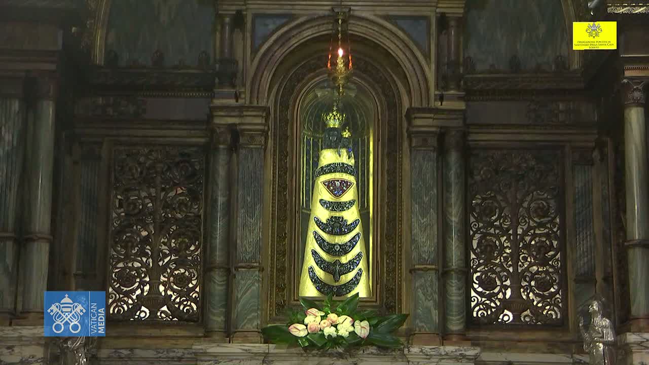 An ornate, gold-and-jewel-encrusted religious statue is displayed within an elaborate, dark-wood alcove.