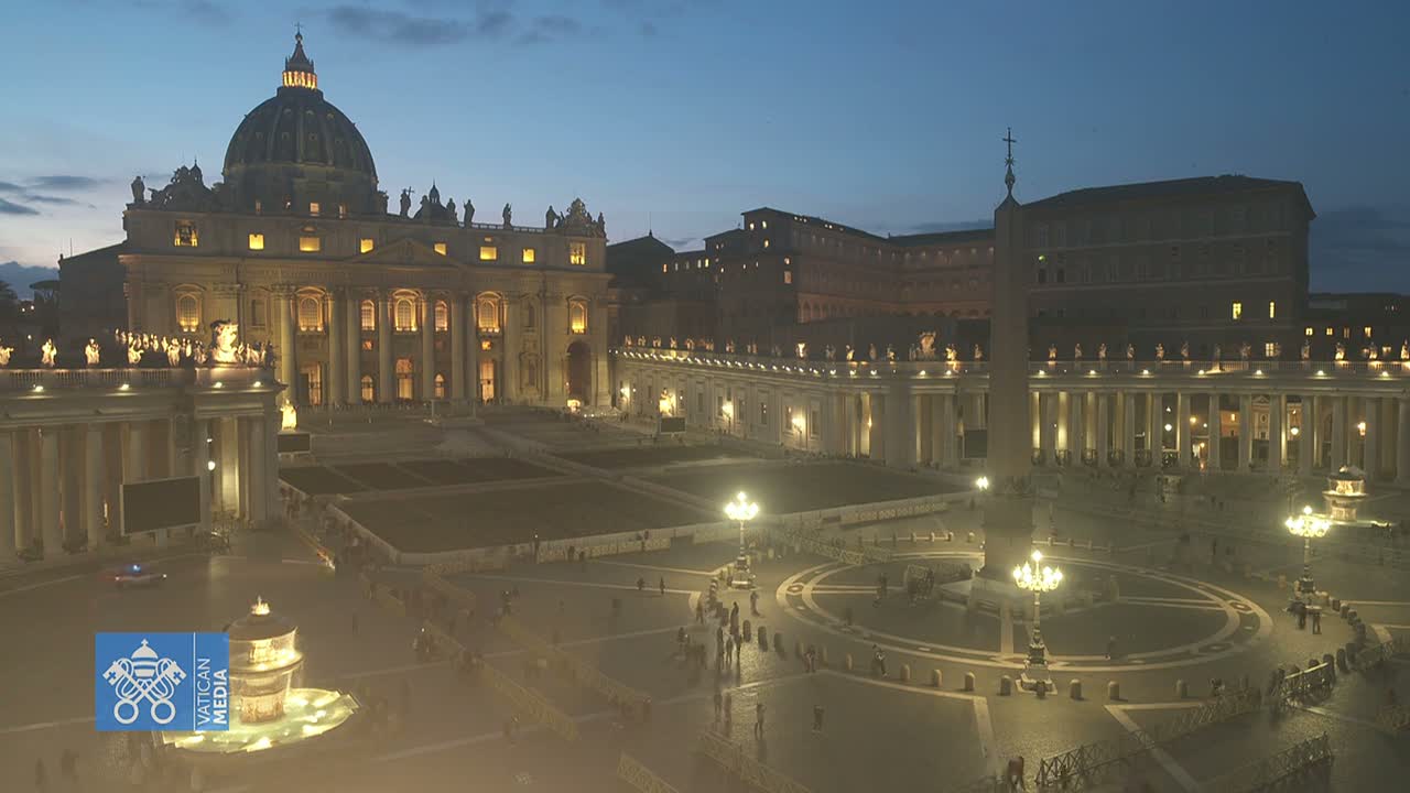 St. Peter's Basilica and Square are illuminated at night under a twilight sky.