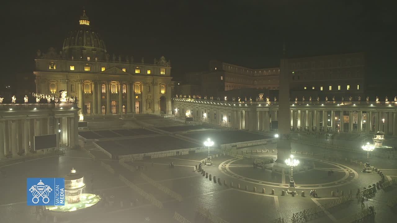 A brightly lit St. Peter's Square and Basilica at night.