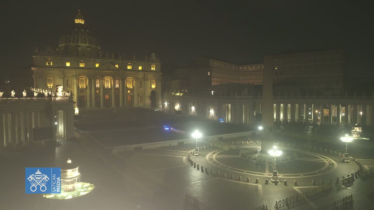 St. Peter's Basilica and St. Peter's Square are illuminated at night in foggy conditions.