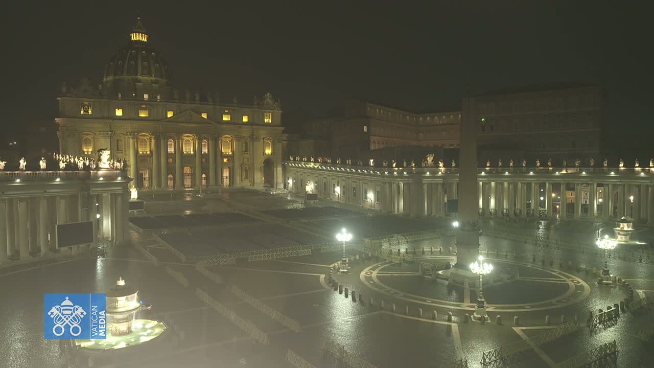St. Peter's Basilica and Square at night in the rain, illuminated by lights.