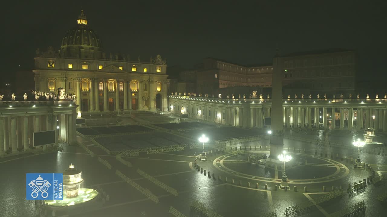 St. Peter's Basilica and Square are illuminated at night in the rain.