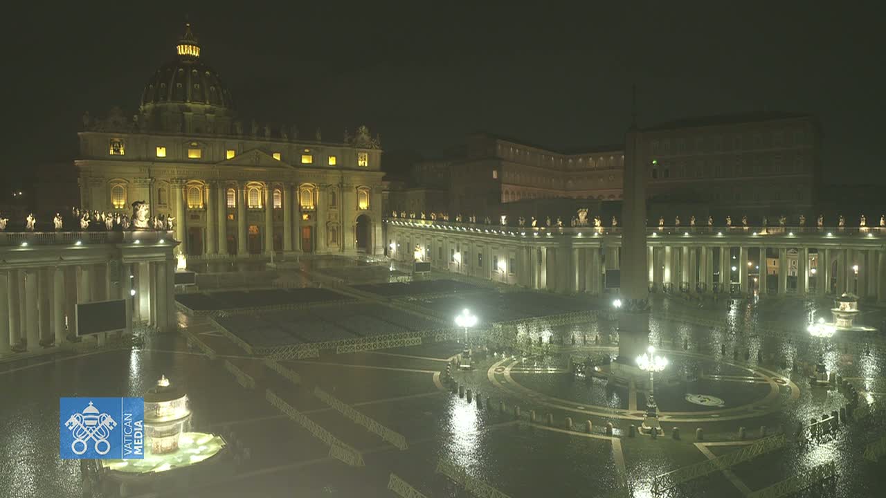 St. Peter's Basilica and Square at night in the rain, illuminated by lights.