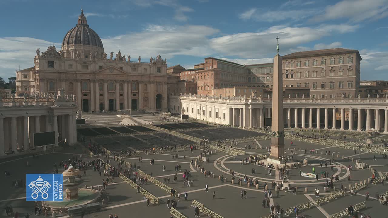 A sunny day reveals St. Peter's Basilica and St. Peter's Square in Vatican City, populated by a number of people.