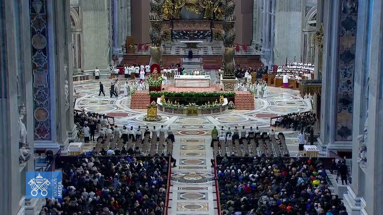 A large crowd of people are seated in a grand, ornate church during what appears to be a religious ceremony.